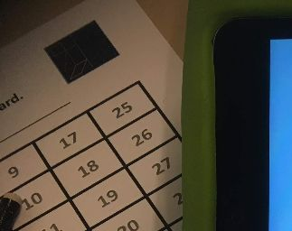 En elevs arbejdssituation. Ipad, arbejdskort og et afkrydsningsskema.